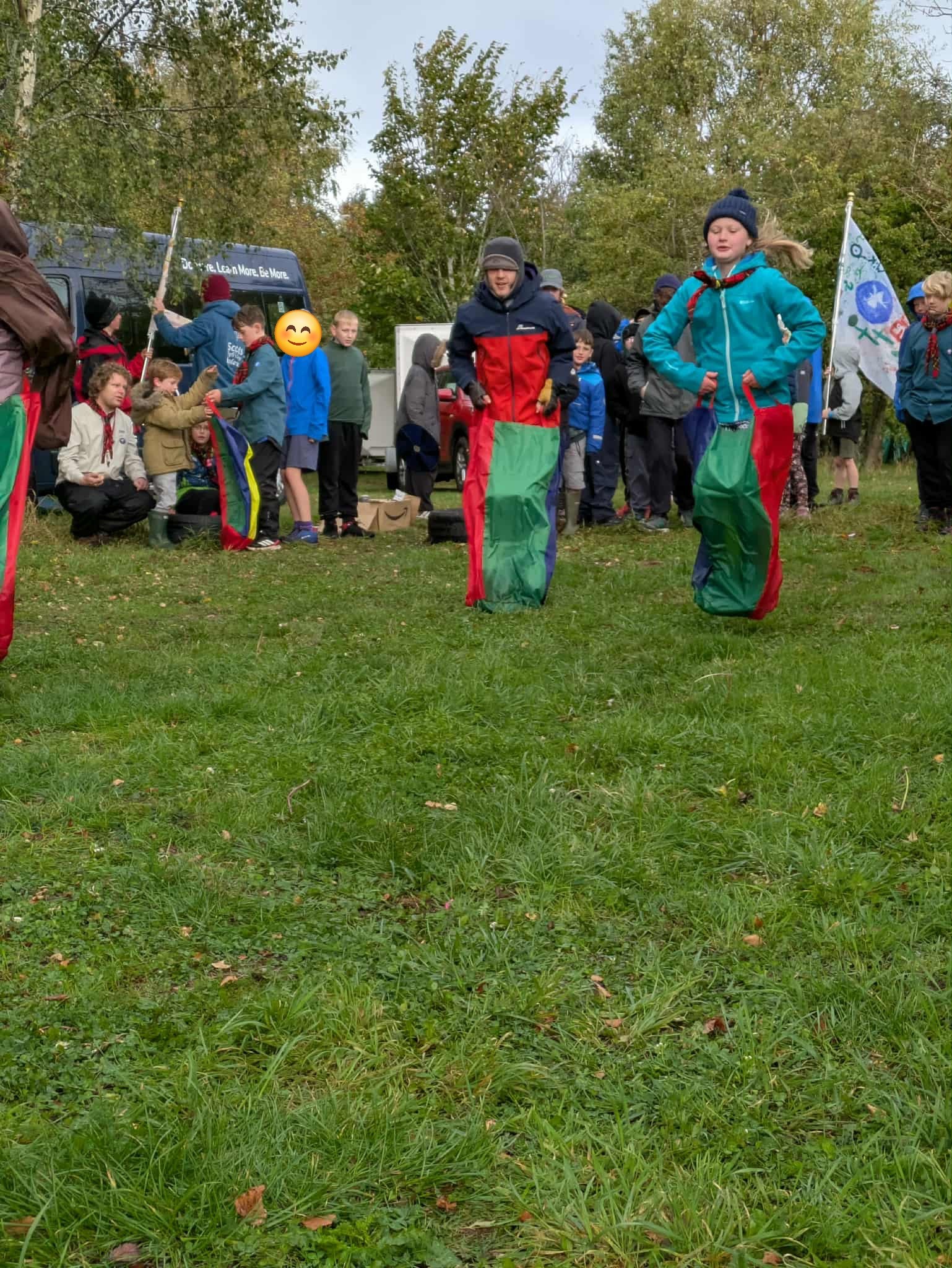 Scouts taking part in a sack race at an outdoor event